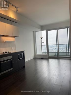 Vaughan (Vaughan Corporate Centre) condo for rent - A kitchen with dark wood floors and white cabinets.