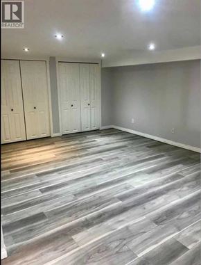 Lethbridge apartment for rent - A room with grey wooden flooring and white walls.