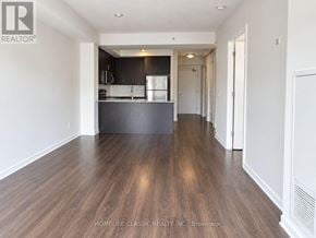 Toronto (Downsview-Roding-Cfb) condo for rent - A spacious kitchen with dark wood floors and white walls.