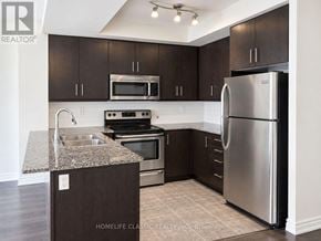 Toronto (Downsview-Roding-Cfb) condo for rent - A kitchen with dark brown cabinets and stainless steel appliances.