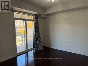 Brampton (Westgate) townhouse for rent - A room with a sliding glass door and a window with a curtain.