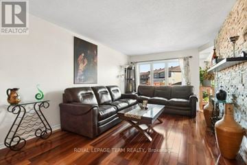 Ottawa townhouse for rent - A living room with a large painting on the wall and a leather sofa.
