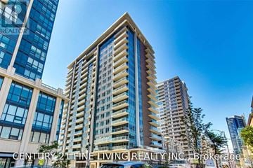 Toronto (Niagara) condo for rent - A tall building with a mix of blue and beige windows stands in front of other buildings.