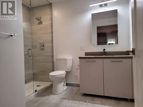 Markham (Commerce Valley) condo for rent - A bathroom with a toilet, sink, and mirror.