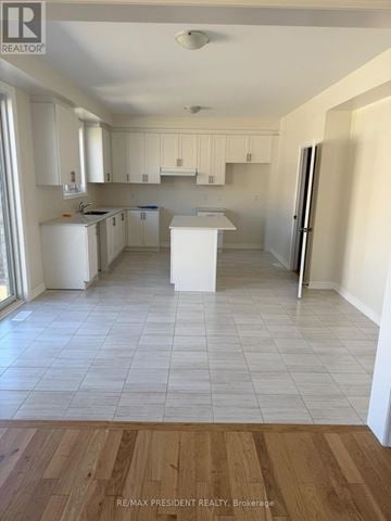 New Tecumseth apartment for rent - A kitchen with white cabinets and a white island.
