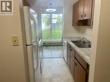Lethbridge apartment for rent - A kitchen with a refrigerator, sink, and cabinets.