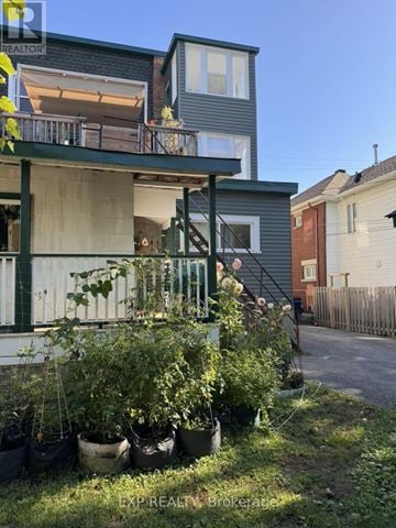 Ottawa multi-family for rent - A house with a balcony and potted plants in front.