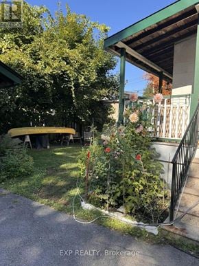Ottawa multi-family for rent - A small garden with a fence and a yellow object in the background.