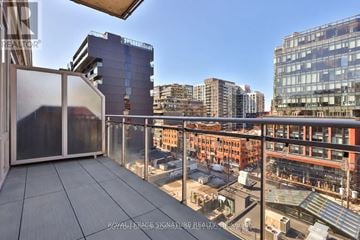 Toronto (Waterfront Communities) condo for rent - A balcony with a glass railing overlooks a cityscape.