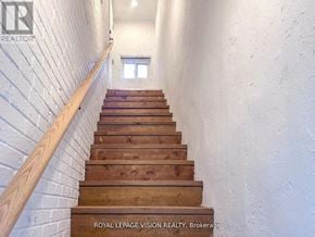 Toronto (Danforth Village-East York) multi-family for rent - A staircase with wooden steps and a white wall.