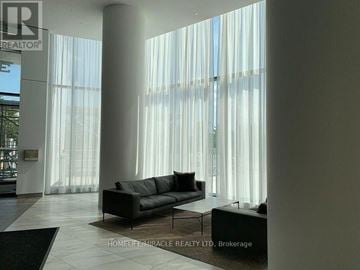 Mississauga (City Centre) condo for rent - A living room with a black couch and a glass table.