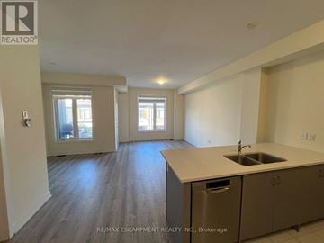 Hamilton (Lakeshore) townhouse for rent - A kitchen with a sink and cabinets in a room with a window.
