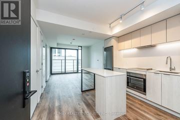 Hamilton (Beasley) condo for rent - A modern kitchen with a refrigerator on the left and a dining area in the background.