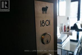 Toronto (Waterfront Communities) condo for rent - A door with a lock and a keyhole is shown with a sheep logo and the number 1801 on it.