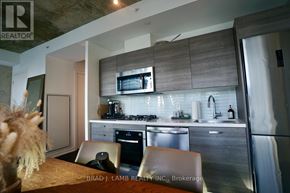 Toronto (Waterfront Communities) condo for rent - A modern kitchen with a stainless steel refrigerator, microwave, and oven.