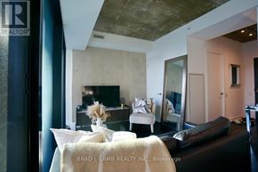 Toronto (Waterfront Communities) condo for rent - A living room with a couch, a chair, and a mirror.