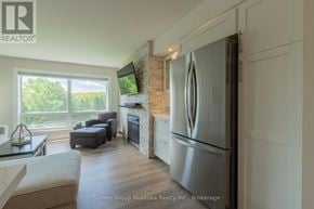 Huntsville (Chaffey) condo for rent - A modern kitchen with a refrigerator and a fireplace.
