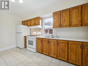 Toronto (Yorkdale-Glen Park) apartment for rent - A kitchen with wooden cabinets and white appliances.