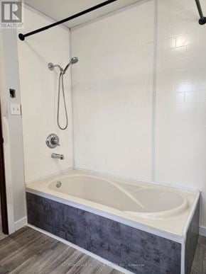 Cambridge apartment for rent - A white bathroom with a bathtub and a shower.