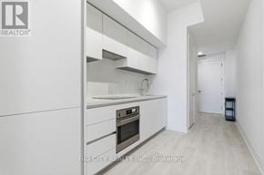 Toronto (Thorncliffe Park) condo for rent - A modern kitchen with white cabinets and a stainless steel oven.