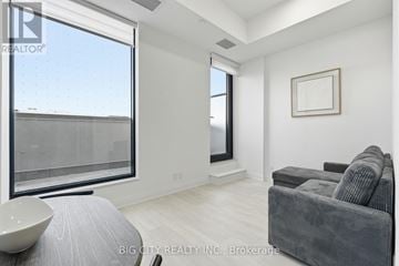Toronto (Thorncliffe Park) condo for rent - A living room with a grey couch and a large window.