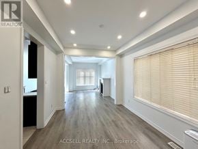 Brampton (Credit Valley) apartment for rent - A spacious room with wooden flooring and a large window with blinds.
