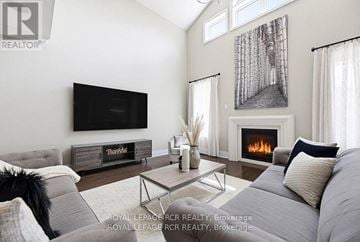 Mono apartment for rent - A living room with a grey couch, a coffee table, a fireplace, and a painting on the wall.