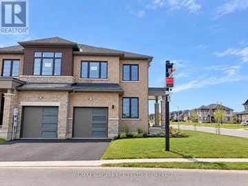 Thorold (Rolling Meadows) townhouse for rent - A modern house with a brown and beige exterior and a black garage door.