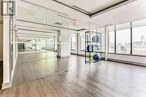 Mississauga (City Centre) condo for rent - A spacious room with a glass wall and a view of the city.