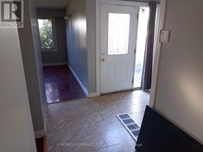 Kitchener apartment for rent - A hallway with a white door and a tiled floor.