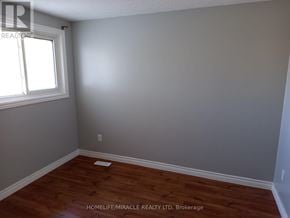 Kitchener apartment for rent - A room with a window and wooden flooring.