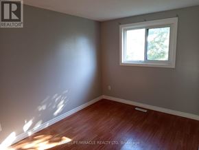 Kitchener apartment for rent - A room with a window and wooden flooring.