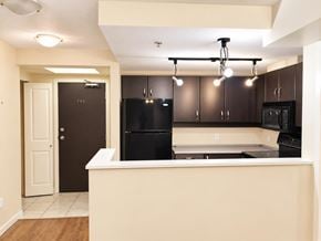 Surrey apartment for rent - A kitchen with black appliances and brown cabinets.