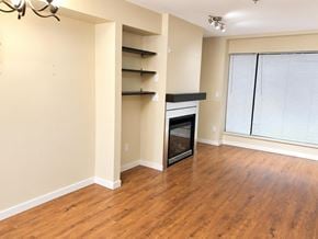 Surrey apartment for rent - A room with a fireplace and wooden floors.