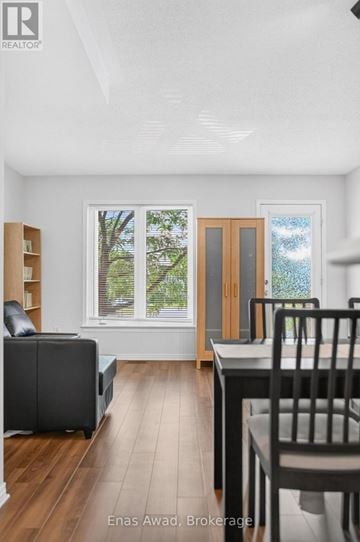 Ottawa townhouse for rent - A modern living room with a black leather sofa and a wooden dining table.