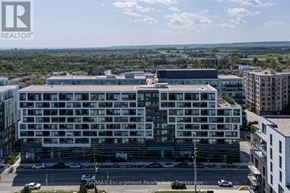 Oakville (Wm Westmount) condo for rent - A large white building with a parking lot in front of it.