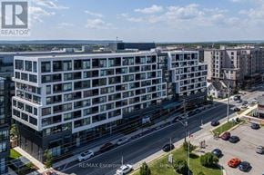 Oakville (Wm Westmount) condo for rent - A modern multi-story building with a parking lot in front.