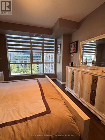 Toronto (Niagara) condo for rent - A bedroom with a large bed and a window with blinds.