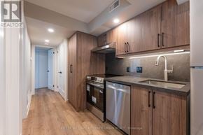 Toronto (Blake-Jones) apartment for rent - A modern kitchen with wooden cabinets and stainless steel appliances.