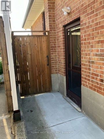 Toronto (Willowridge-Martingrove-Richview) apartment for rent - A wooden gate is closed on a brick wall.
