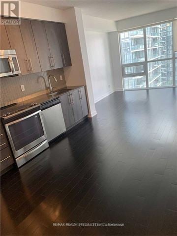 Mississauga (City Centre) condo for rent - A kitchen with a stove top oven and a microwave.