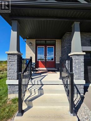 Haldimand apartment for rent - A house entrance with a red door and a stone pillar.