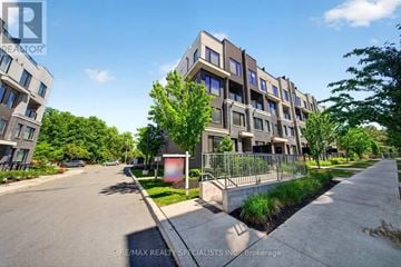 Mississauga (Erin Mills) townhouse for rent - A street view of a residential area with apartment buildings and a clear blue sky.