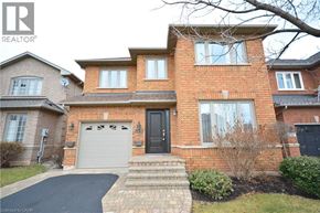Oakville apartment for rent - A large brick house with a black door and a garage.