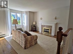 Burnaby apartment for rent - A living room with a couch, a fireplace, and a lamp.