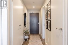 St. Catharines (Port Dalhousie) condo for rent - A hallway with a rug, a door, and pictures on the wall.