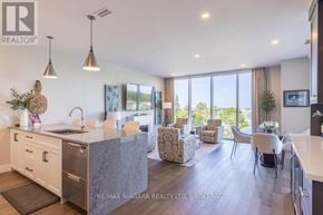 St. Catharines (Port Dalhousie) condo for rent - A modern kitchen with a large island and a dining area with chairs.