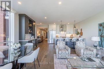 St. Catharines (Port Dalhousie) condo for rent - A modern living room with a glass table and chairs.