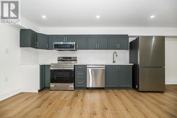 Ajax (Central West) apartment for rent - A kitchen with dark green cabinets and stainless steel appliances.