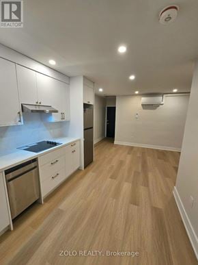 Toronto (Bedford Park-Nortown) apartment for rent - A kitchen with white cabinets and a wooden floor.